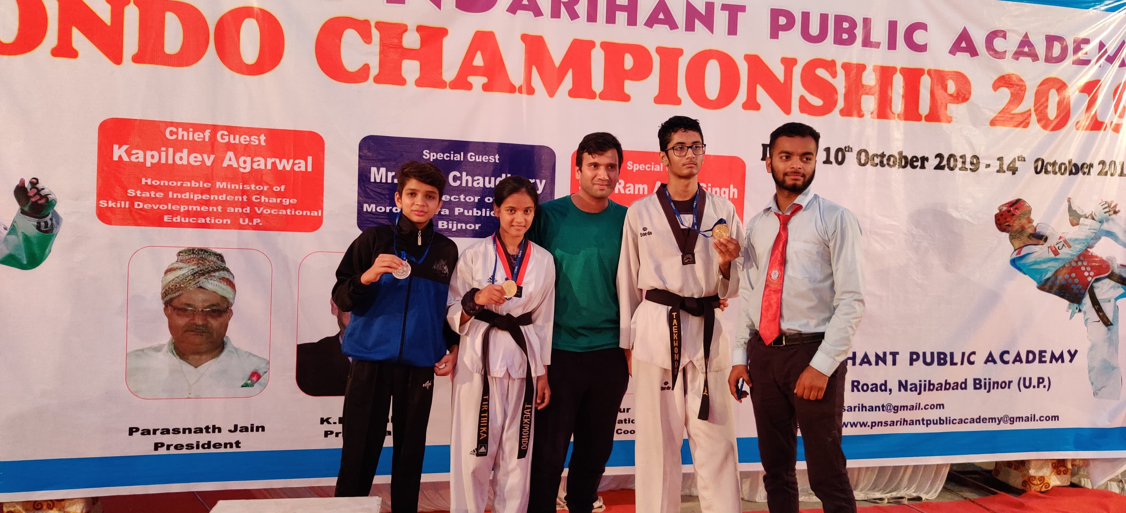 Master Abhishek with four medal-winning athletes on a championship podium.